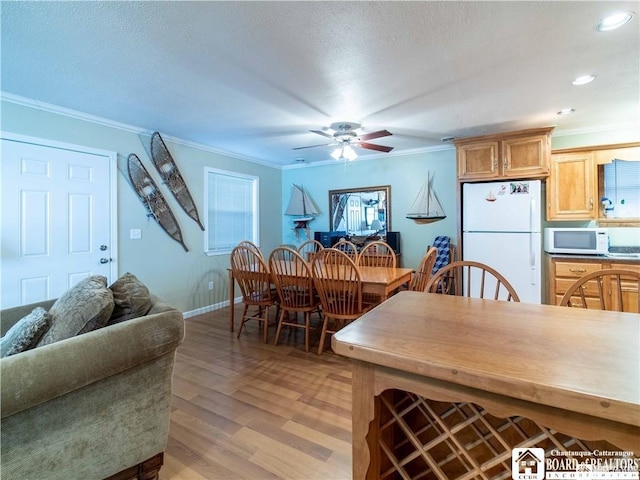 kitchen featuring crown molding, white appliances, ceiling fan, light hardwood / wood-style floors, and a textured ceiling