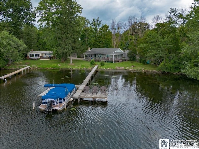 dock area with a lawn and a water view