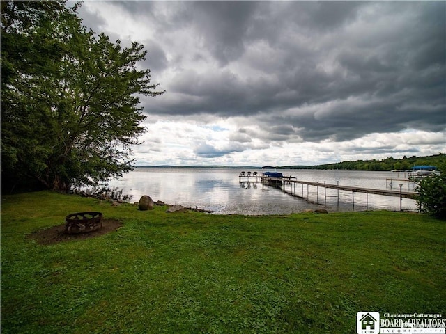 view of dock featuring a water view and a yard