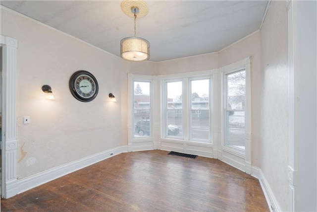 unfurnished dining area featuring ornamental molding, dark hardwood / wood-style floors, and a wealth of natural light