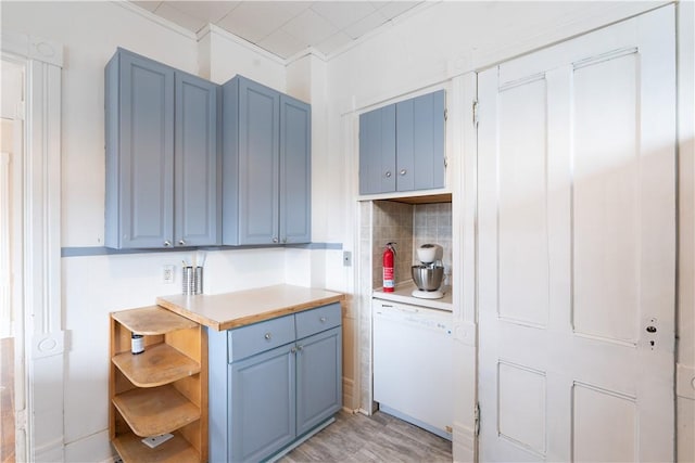 kitchen featuring tasteful backsplash, ornamental molding, dishwasher, and blue cabinets