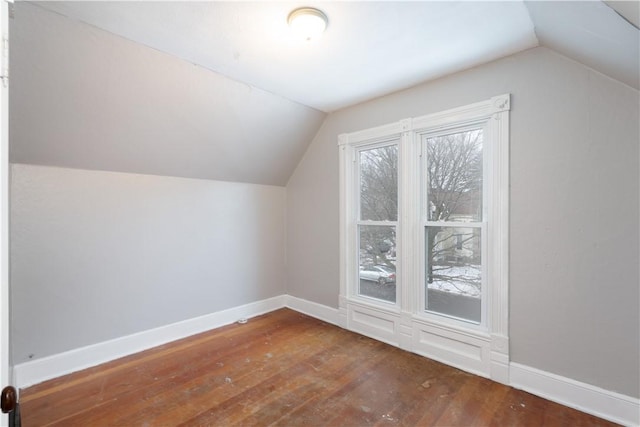 additional living space featuring vaulted ceiling and dark hardwood / wood-style floors