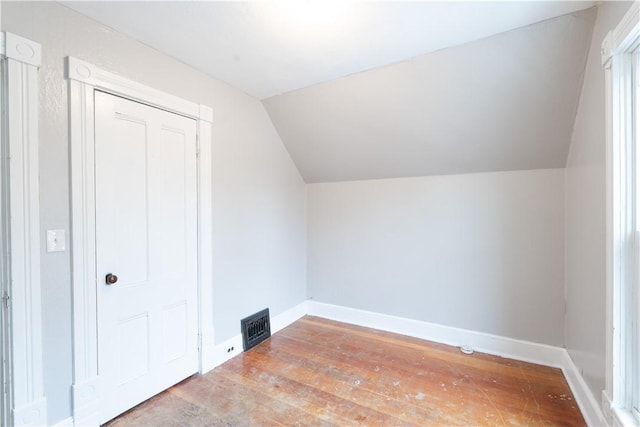 additional living space with vaulted ceiling and wood-type flooring