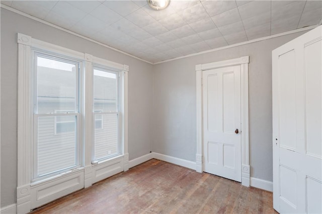 empty room featuring crown molding and light wood-type flooring