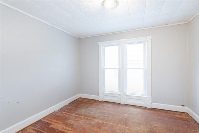 empty room with crown molding and dark wood-type flooring