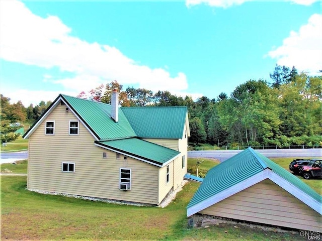 back of house with cooling unit and a lawn