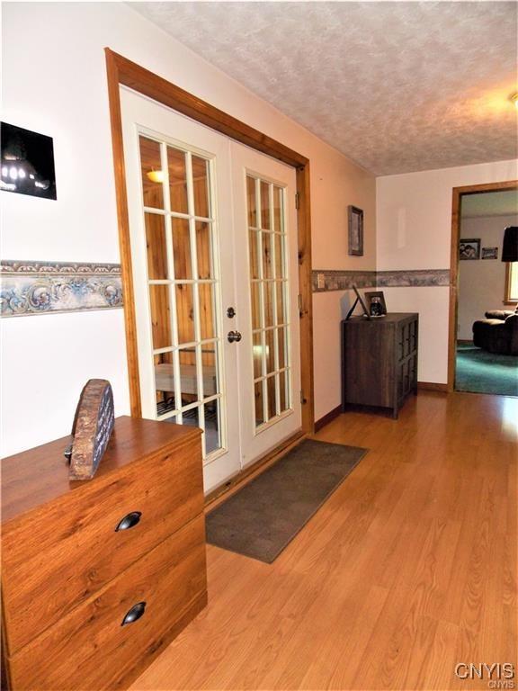 doorway to outside featuring hardwood / wood-style floors, a textured ceiling, and french doors