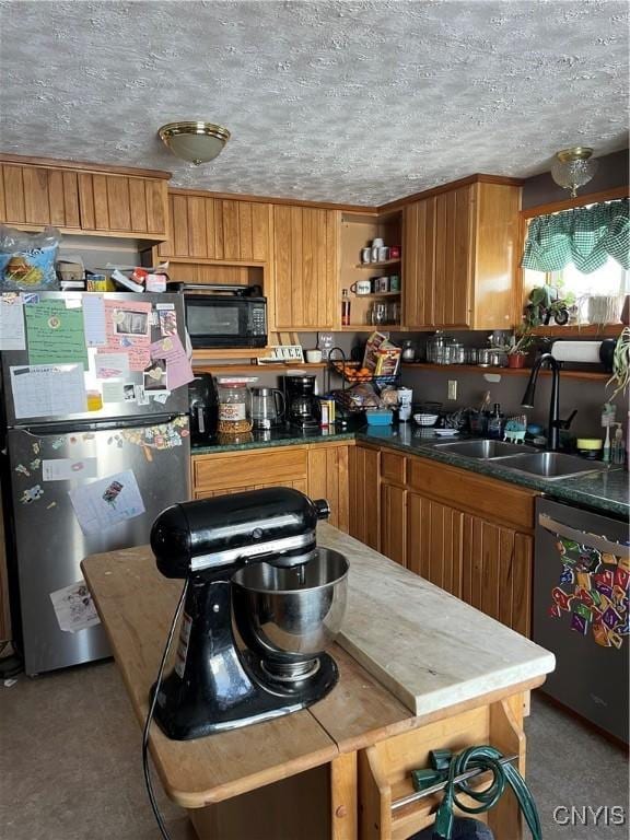 kitchen featuring appliances with stainless steel finishes, sink, and a textured ceiling