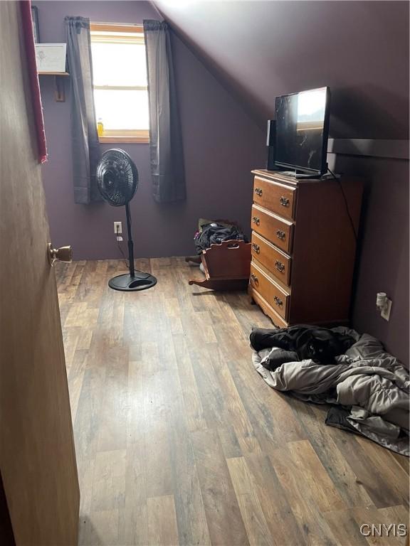 bedroom with vaulted ceiling and light wood-type flooring