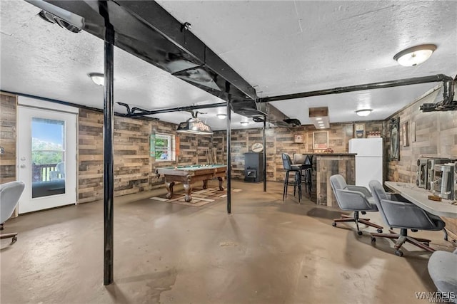 basement with billiards, bar, white fridge, and a textured ceiling