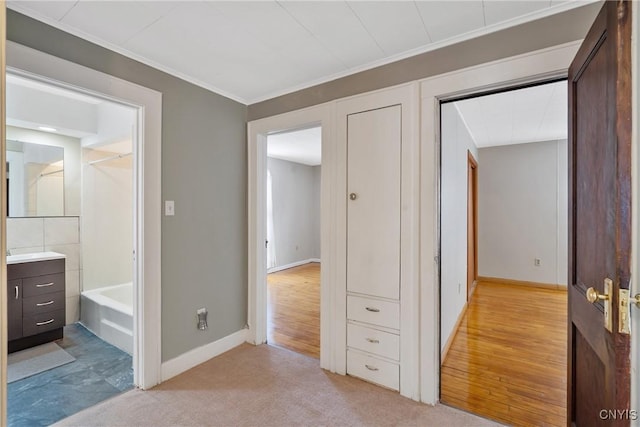 corridor with light colored carpet and ornamental molding