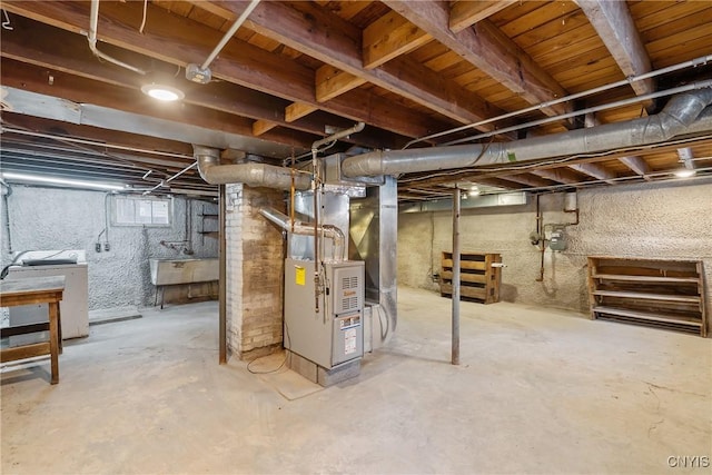 basement featuring washer / dryer, sink, and heating unit