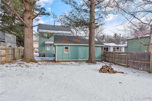 view of snow covered rear of property