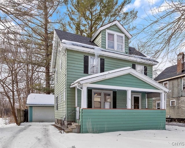 view of front of home with a garage and an outbuilding