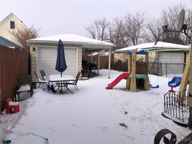 snow covered patio featuring a playground