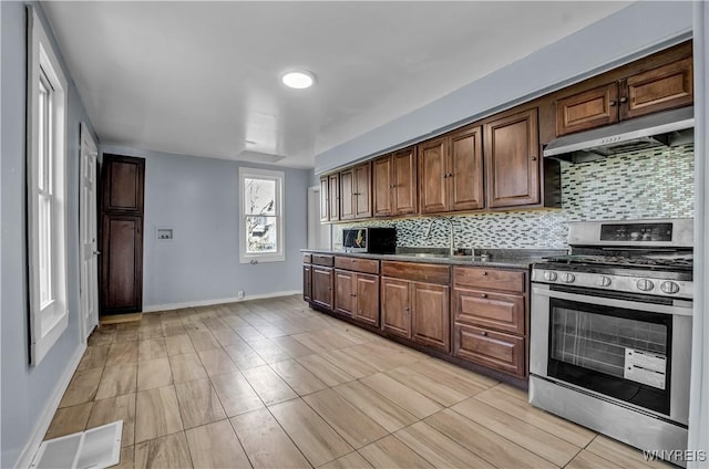 kitchen with gas range, sink, backsplash, and extractor fan