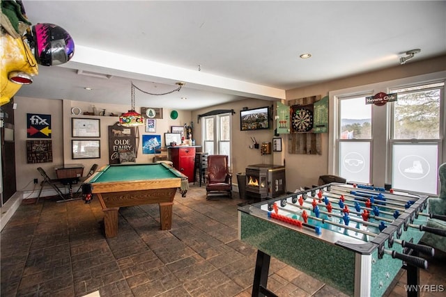 rec room with a healthy amount of sunlight, a wood stove, and pool table