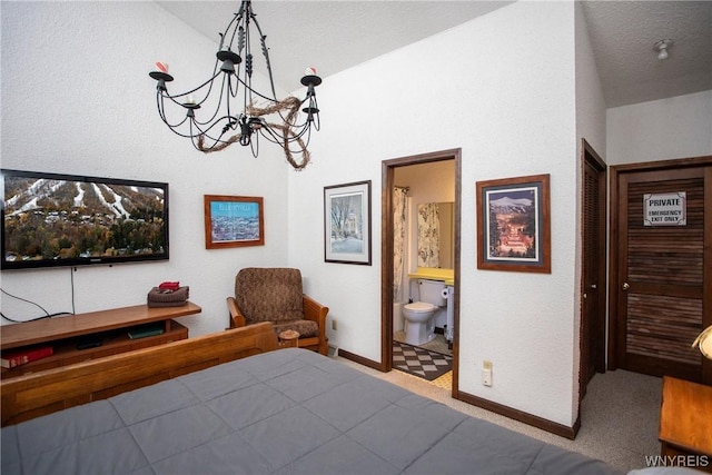 bedroom with vaulted ceiling, a chandelier, and ensuite bathroom