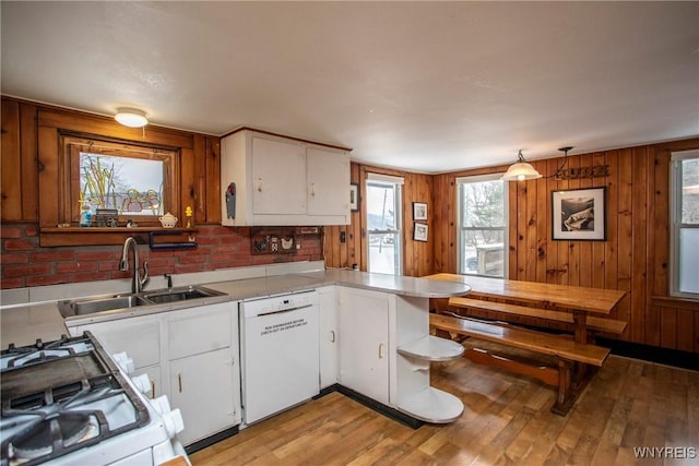 kitchen with white cabinetry, white appliances, sink, and hanging light fixtures