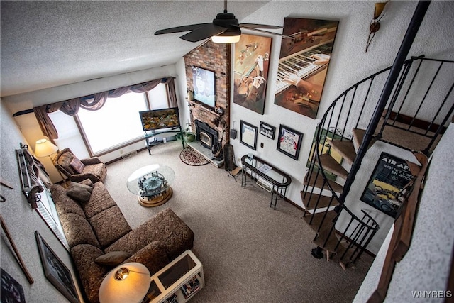 living room featuring vaulted ceiling, a textured ceiling, a large fireplace, carpet floors, and ceiling fan