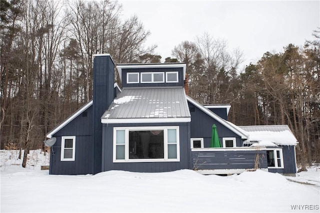 view of snow covered back of property