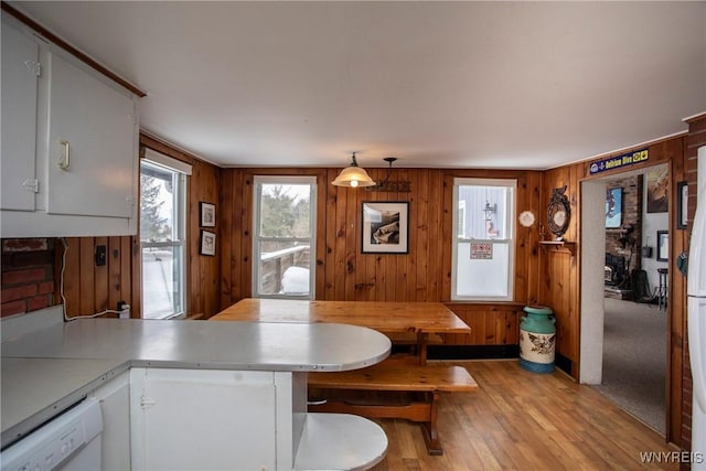 kitchen with pendant lighting, white dishwasher, white cabinets, breakfast area, and kitchen peninsula