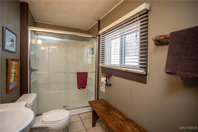 bathroom featuring sink, tile patterned flooring, toilet, a shower with door, and crown molding