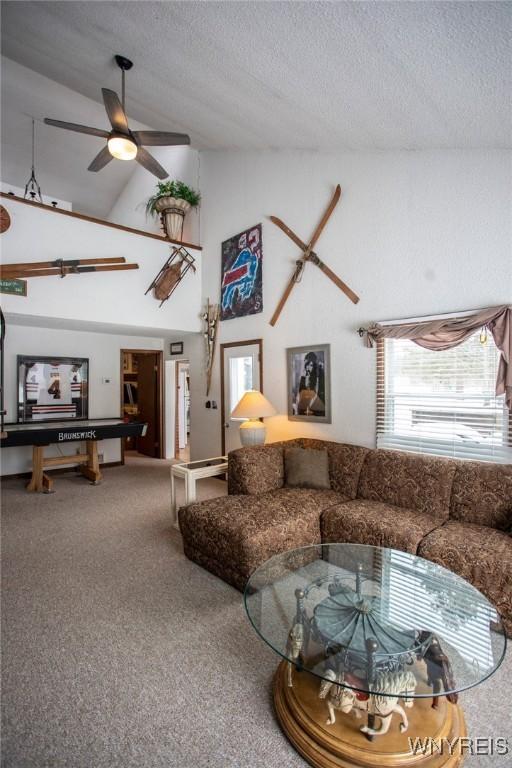 living room with ceiling fan, a textured ceiling, and carpet flooring