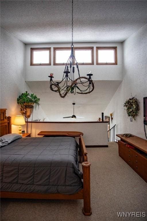 carpeted bedroom with multiple windows, a chandelier, and a textured ceiling