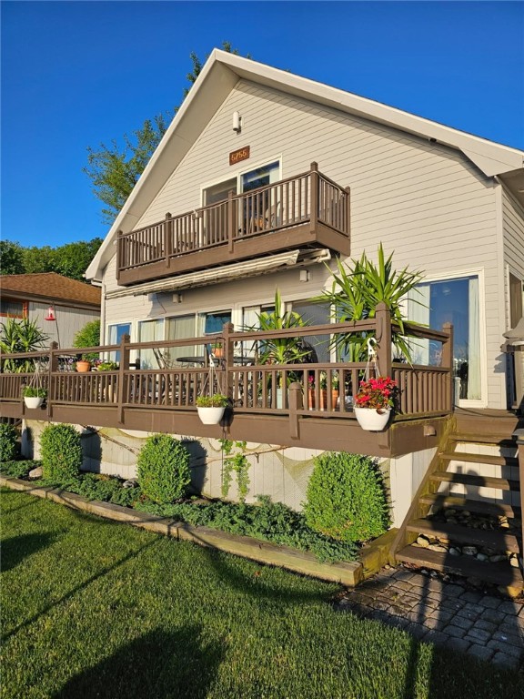 back of property featuring a balcony and a yard