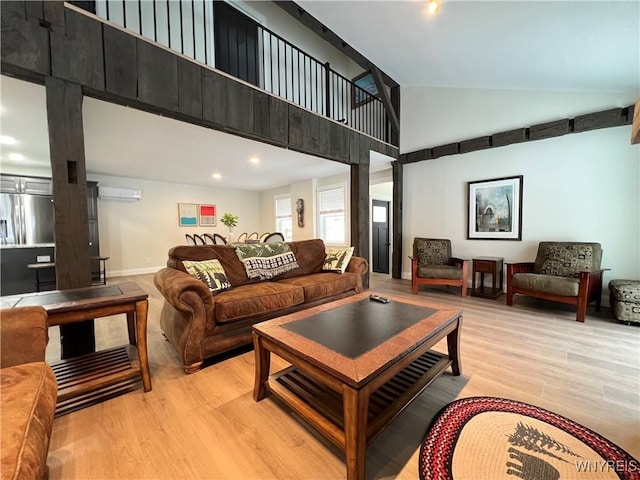 living room featuring high vaulted ceiling, light hardwood / wood-style floors, and an AC wall unit