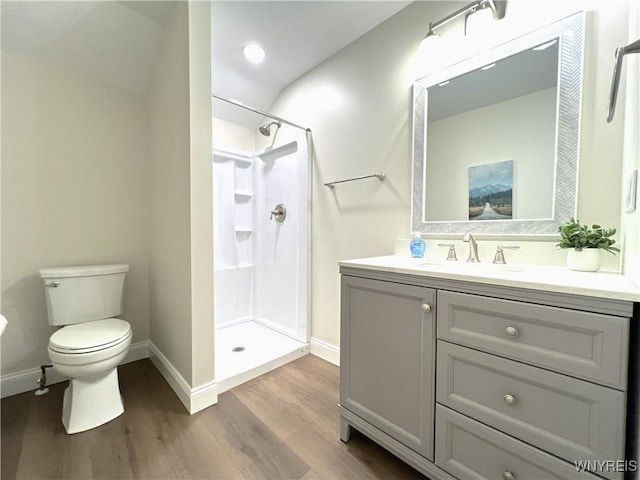 bathroom featuring hardwood / wood-style flooring, vanity, toilet, and walk in shower