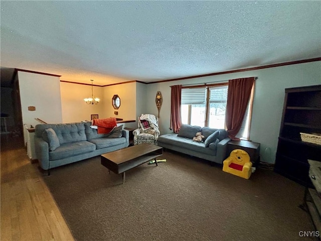 living room featuring ornamental molding, hardwood / wood-style floors, a notable chandelier, and a textured ceiling