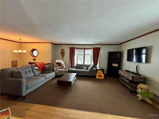 living room featuring hardwood / wood-style flooring, ornamental molding, a textured ceiling, and a chandelier