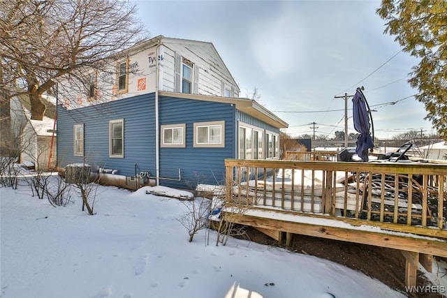 snow covered rear of property featuring a deck