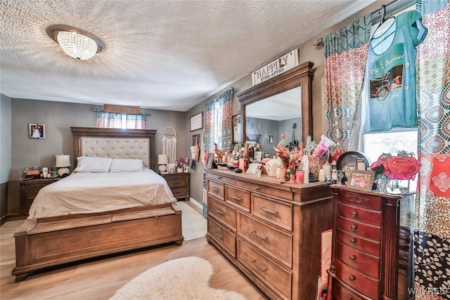 bedroom with a textured ceiling and light hardwood / wood-style flooring