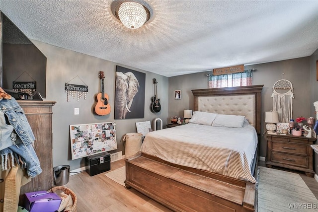 bedroom featuring a textured ceiling and light wood-type flooring