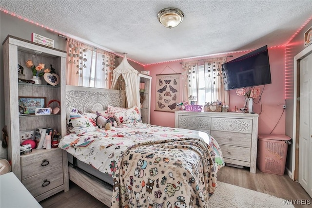 bedroom featuring a textured ceiling and light wood-type flooring