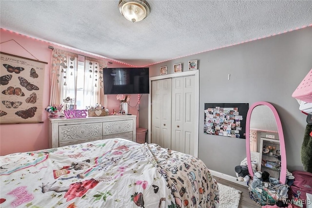 bedroom featuring hardwood / wood-style flooring, a textured ceiling, and a closet