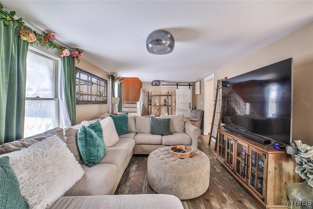 living room with dark wood-type flooring and a barn door