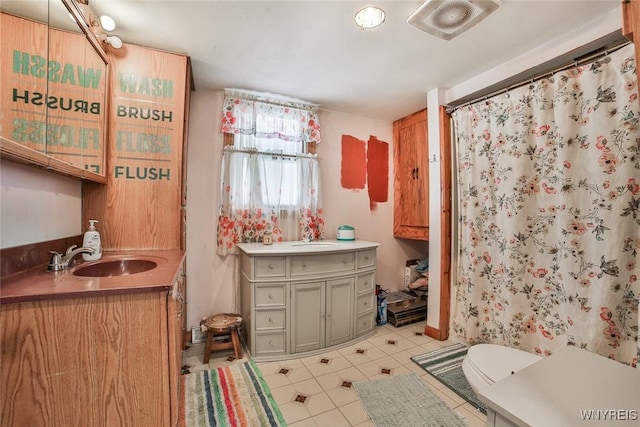 bathroom with vanity, tile patterned flooring, toilet, and walk in shower