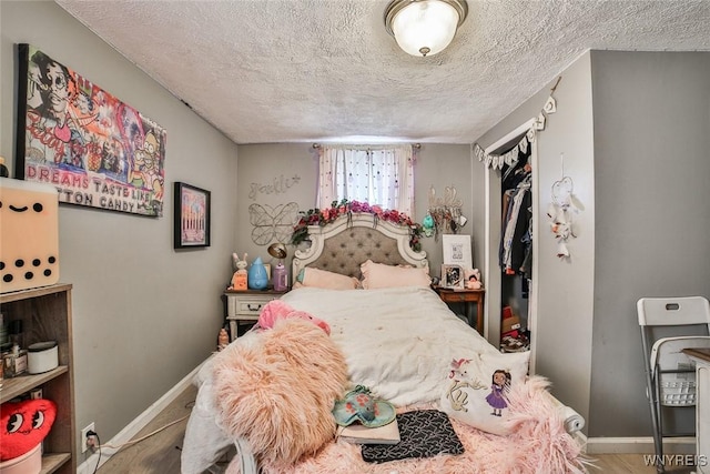 bedroom with hardwood / wood-style flooring, a closet, and a textured ceiling