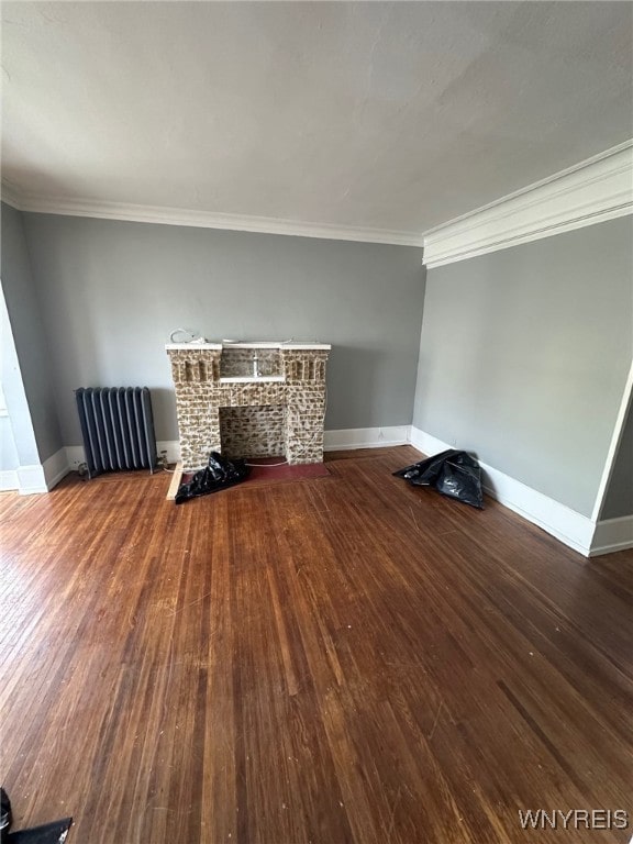 unfurnished living room with crown molding, radiator heating unit, a fireplace, and wood-type flooring