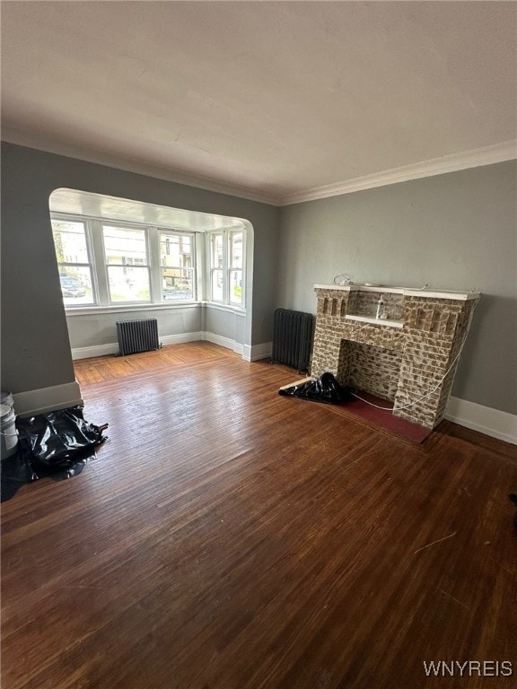 unfurnished living room featuring crown molding, wood-type flooring, and radiator