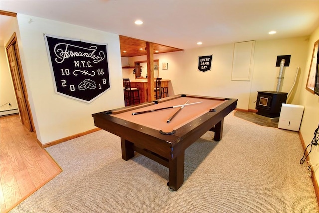 recreation room featuring a wood stove, baseboard heating, and billiards