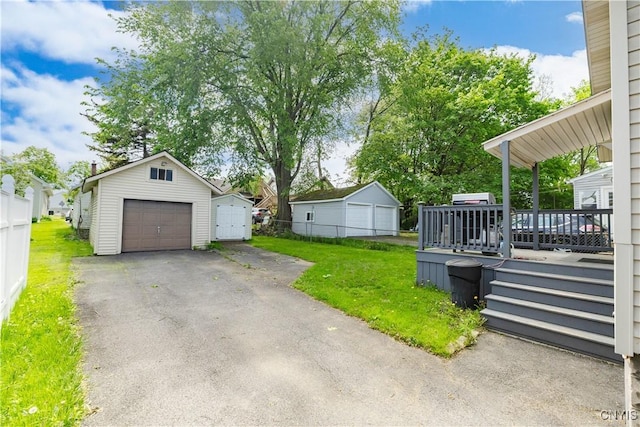 1407 Downer Ave, Utica, NY 13502 - view of yard featuring a garage, an outbuilding, asphalt driveway, and a wooden deck