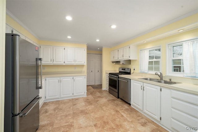 kitchen with white cabinetry, ornamental molding, appliances with stainless steel finishes, and sink