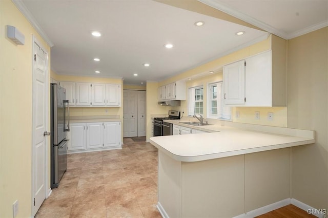 kitchen featuring stainless steel appliances, kitchen peninsula, sink, and white cabinets