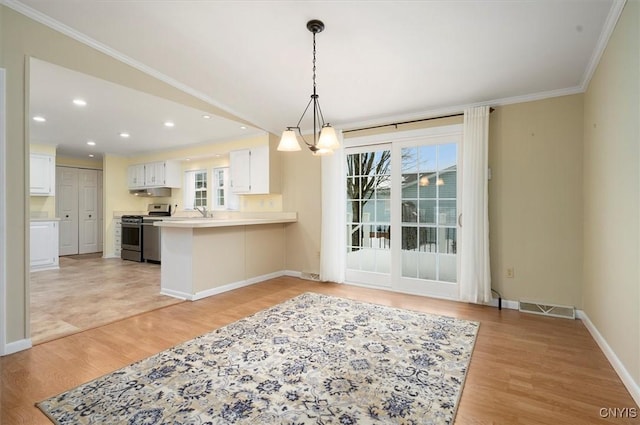 kitchen with white cabinets, stainless steel range, light hardwood / wood-style floors, kitchen peninsula, and crown molding