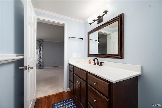 bathroom featuring hardwood / wood-style flooring, ornamental molding, and vanity